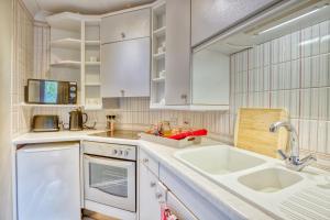 a kitchen with white cabinets and a sink at Pass the Keys Cosy Hideaway in the Countryside in Lincoln