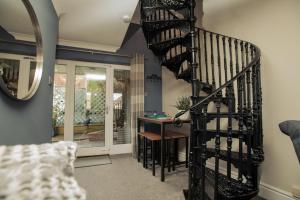 a spiral staircase in a living room with a table at Pass the Keys Cosy Hideaway in the Countryside in Lincoln