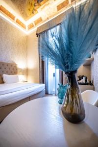 a vase with blue feathers sitting on a table in a room at Martelli 6 Suite & Apartments in Florence