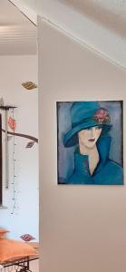 a painting of a woman in a blue hat on a wall at Ferienwohnung mit Moselblick in Piesport