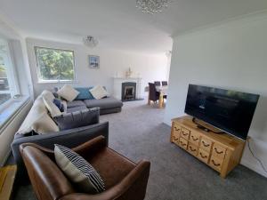 a living room with a couch and a flat screen tv at Seasalt and Seasalt Cabin, Seaview in Seaview