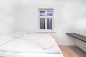 City Point Reykjavik - Luxury Apartments - Surtsey في ريكيافيك: غرفة بيضاء مع سرير ونافذة