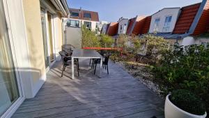 a patio with a table and chairs on a balcony at Kapitänshaus Roseney in Norderney