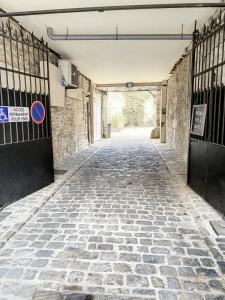 an empty alley with a stone floor and a gate at Charmant triplex centre-ville de Chantilly in Chantilly