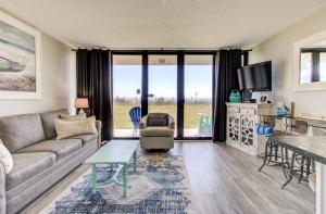 a living room with a couch and a table at 0103 Relax You're At The Beach by Atlantic Towers in Carolina Beach