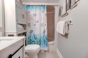 a bathroom with a toilet and a shower curtain at 0103 Relax You're At The Beach by Atlantic Towers in Carolina Beach