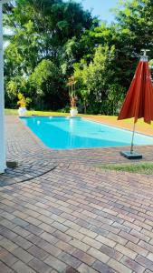 an umbrella sitting next to a swimming pool at La Lucia Sleepover in Durban