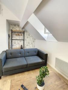 una sala de estar con un sofá azul en un ático en Appart Cosy Hyper Centre Duplex Gare Amiens 2 Pers, en Amiens