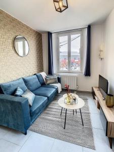 - un salon avec un canapé bleu et une table dans l'établissement Appart Hyper Centre Tout Confort Wifi 4 Pers, à Romilly-sur-Seine