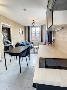 a kitchen and living room with a table and a couch at Appart Hyper Centre Tout Confort Wifi 4 Pers in Romilly-sur-Seine