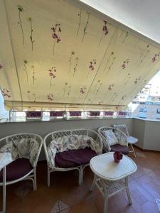 a room with two chairs and a wall with flowers at 3 Bedroom Apartment in Tirana