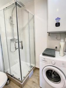 La salle de bains est pourvue d'un lave-linge et d'une douche. dans l'établissement Appart Hyper Centre Tout Confort Wifi 4 Pers, à Romilly-sur-Seine