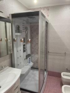 a bathroom with a shower and a sink and a toilet at 3 Bedroom Apartment in Tirana