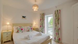1 dormitorio con cama y ventana en Robin Cottage, en Reynoldston