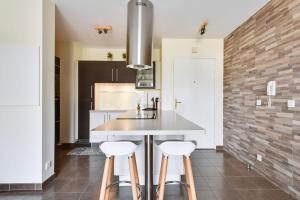 a kitchen with a table and two stools at Appart Cosy Quartier Calme Hyper Centre Parking in Magny-le-Hongre