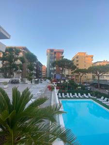 vistas a una piscina con sillas y edificios en Hotel Nautilus, en Bellaria-Igea Marina