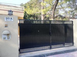 a black gate with a sign on the side of a building at Executive Royal Garden in Islamabad