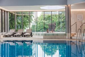 a swimming pool with a woman in a bath tub at Swindon Blunsdon House Hotel, BW Premier Collection in Swindon