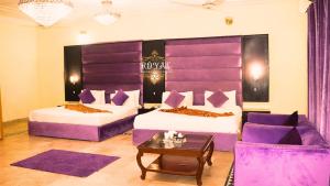 a hotel room with two beds and a couch at Executive Royal Garden in Islamabad