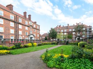 a large brick building with a garden in front of it at Pass The Keys - Spacious Modern 2BR Flat for 6, 3min walk to Hammersmith Station in London