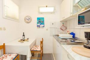 a kitchen with a counter and a table and a sink at Studio Ibis in Dubrovnik
