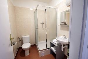 een badkamer met een douche, een toilet en een wastafel bij Hotel Zlatá Váha in Praag