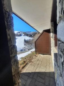 Elle offre une vue sur un bâtiment doté d'une grande porte en bois. dans l'établissement Chez Angélique et Romain - Appartement agréable au pied des pistes, à La Plagne