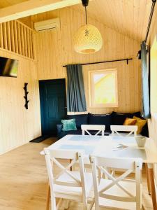 a dining room with a white table and chairs at Osada Chmiel in Chmielno