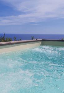 una piscina de agua azul y el océano en Villa Russo Casa Vacanze en Marina di Camerota