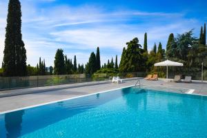 uma piscina com árvores e um céu em Minnie by Garda FeWo em Gardone Riviera
