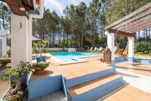 a backyard with a swimming pool with blue steps at Aljezur Villas in Aljezur