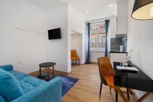 a living room with a blue couch and a table at Lisbon 5 in Lisbon