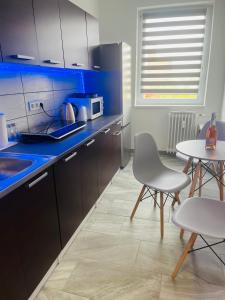 a kitchen with a blue counter and a table and chairs at Horizont-Szilvás Apartman in Komló