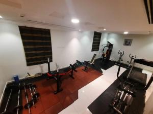a gym with rows of exercise equipment in a room at اجنحة الماسم المخدومة -حى غرناطة in Riyadh