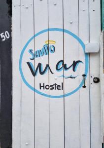 a sign on the side of a white building at SANTO MAR HOSTEL in Arraial do Cabo