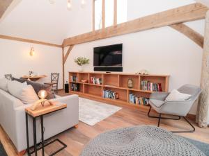 a living room with a white couch and a tv at Beech Barn The Rookery in Kingsbridge