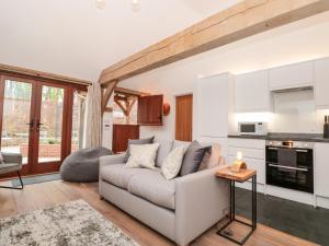 a living room with a couch and a kitchen at Beech Barn The Rookery in Kingsbridge