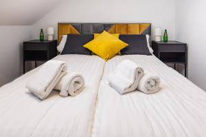 sypialnia z 2 łóżkami i ręcznikami w obiekcie Apartamenty Kamienica Gwiazda w mieście Krynica Zdrój