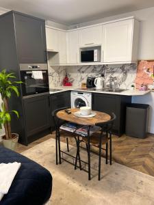 a kitchen with a table and a sink and a microwave at Studio Flat in Wythenshawe