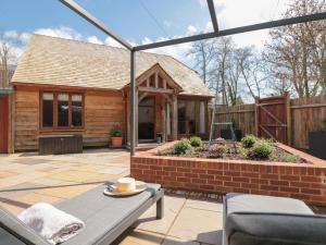 a backyard with a house with a brick patio at Beech Barn The Rookery in Kingsbridge