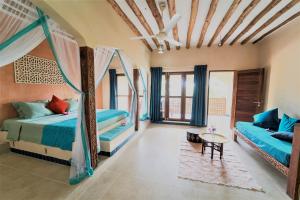 a bedroom with a bed and a couch and a table at Kendwa Rocks Hotel in Kendwa