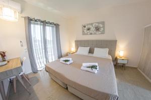 ein Schlafzimmer mit einem Bett mit zwei Handtüchern darauf in der Unterkunft Costas apartments in Mesongi