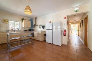 a kitchen with a white refrigerator and a tile floor at Aljezur Villas in Aljezur