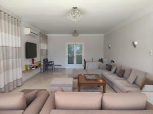 a living room with a couch and a tv at Villa Ambre in Gammarth