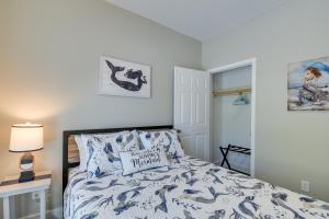 a bedroom with a bed with a blue and white comforter at Charming Ocean Isle Beach Home about 1 Mi to Beach! in Ocean Isle Beach