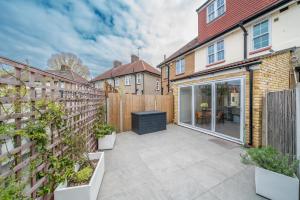 a garden with a patio and a fence at Delightful 3 Bed House by Canary Wharf in London