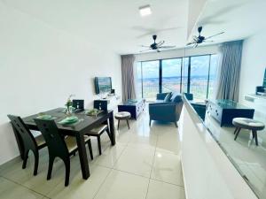 a dining room and living room with a table and chairs at N Cozy 1-10Pax 2Room Trefoil SetiaAlam SmrtTV Wifi in Setia Alam