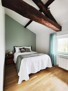 1 dormitorio con cama blanca y ventana en Chambres d'hôtes - Les Varennes, en Saint-Georges-de-Reneins