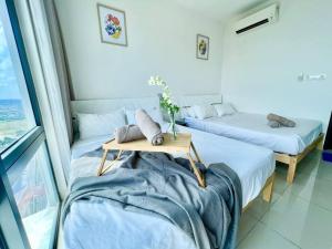 um quarto com duas camas e uma mesa com almofadas em N Cozy 1-10Pax 2Room Trefoil SetiaAlam SmrtTV Wifi em Setia Alam