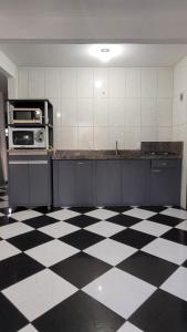 una cocina con suelo a cuadros en blanco y negro en Solar Alcantara & Lazzarotto (Residencial), en Bombinhas